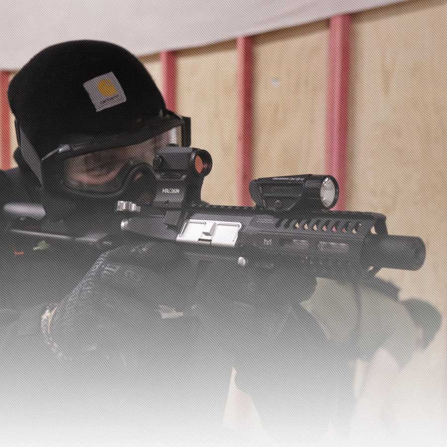 Freedom Firearms & Defense | Law enforcement officer aiming a rifle equipped with a scope.